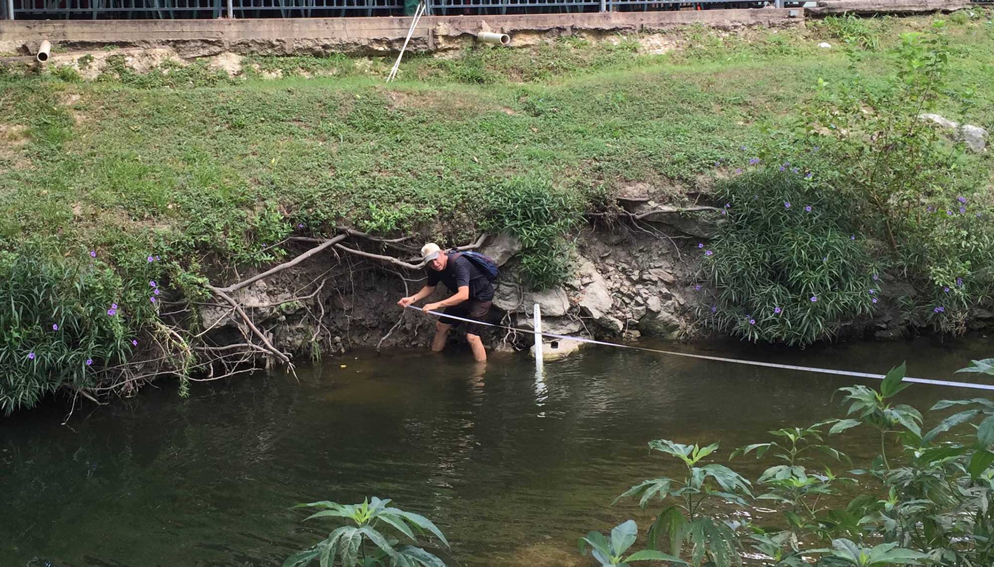 Photo of man makeing measurements of Barton Creek