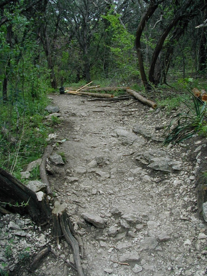 Logs, tools and stone are gathered to repair this eroded trail before the work begins.